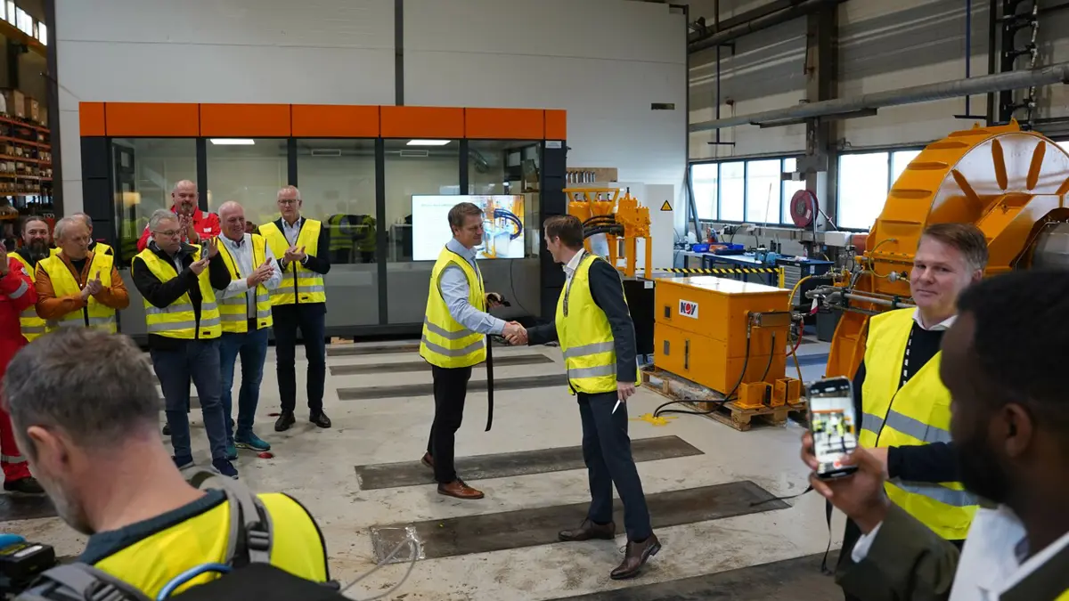 Kristiansand-ordfører Mathias Bernander (H), gratulerer Rune Johnsen, administrerende direktør i NOV. Ordføreren klippet snor foran "Powerblade Energy Recovery System". Et nytt system som gjenvinner energi som ellers forsvinner ut i havet. 
