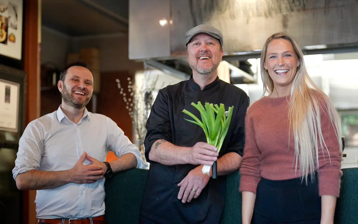 Stor stemning når tre gode krefter slår seg sammen om et kinder-egg av et bærekraftstilbud under Miljøuka! Blå Kors dekker et gjenbruksbord Hos Moi under Spis Grønt Uka, forteller fra venstre prosjektleder i Kvadraturforeningen, Rolf T. Øygarden, leder Trond Moi i Hos Moi og arrangementsansvarlig i Blå Kors Kristiansand, Benedikte Sofie Rom Abrahamsen. Foto: Martin Granum, Blå Kors